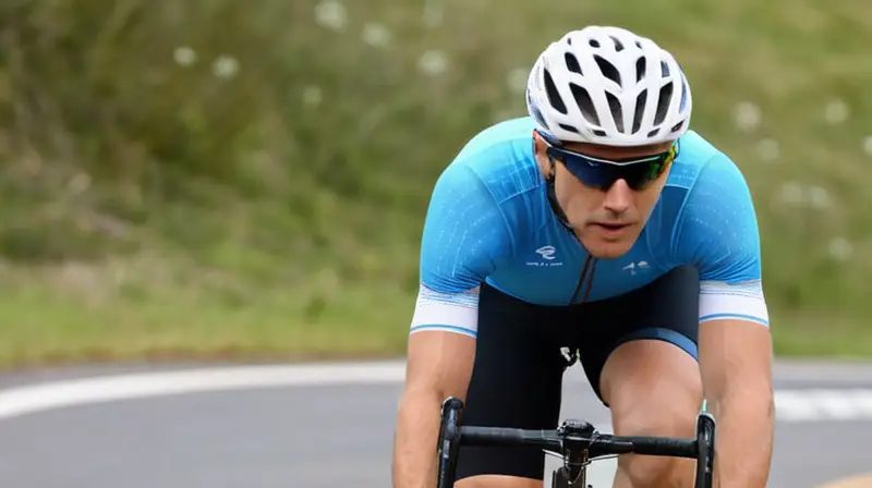 Jersey de ciclismo azul brillante, ajustado y transpirable, con detalles de costura y un ciclista en movimiento en un paisaje desenfocado