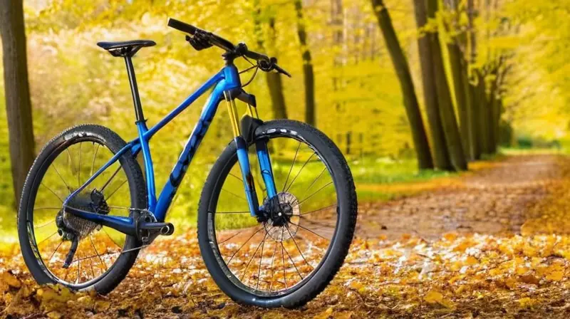 Una bicicleta de montaña Orbea Oiz de marco azul vibrante y detalles en carbono, exhibiendo su diseño y componentes ligeros en un entorno natural