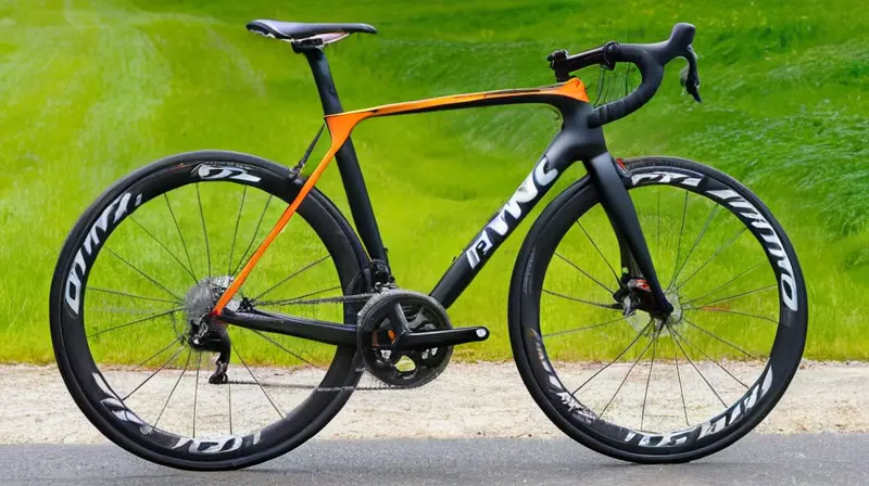 Bicicleta de carbono negra mate con detalles en naranja, diseño ergonómico y componentes Shimano 105, lista para la aventura